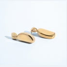 Gold geometric statement earrings with sculptural curved design and polished finish