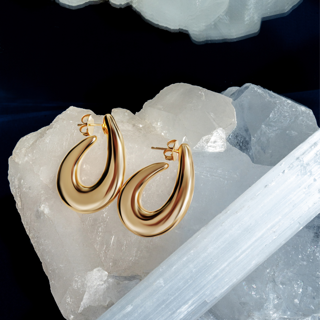 Sculptural hoop earrings available in gold plated and rhodium plated finishes with curved modern design