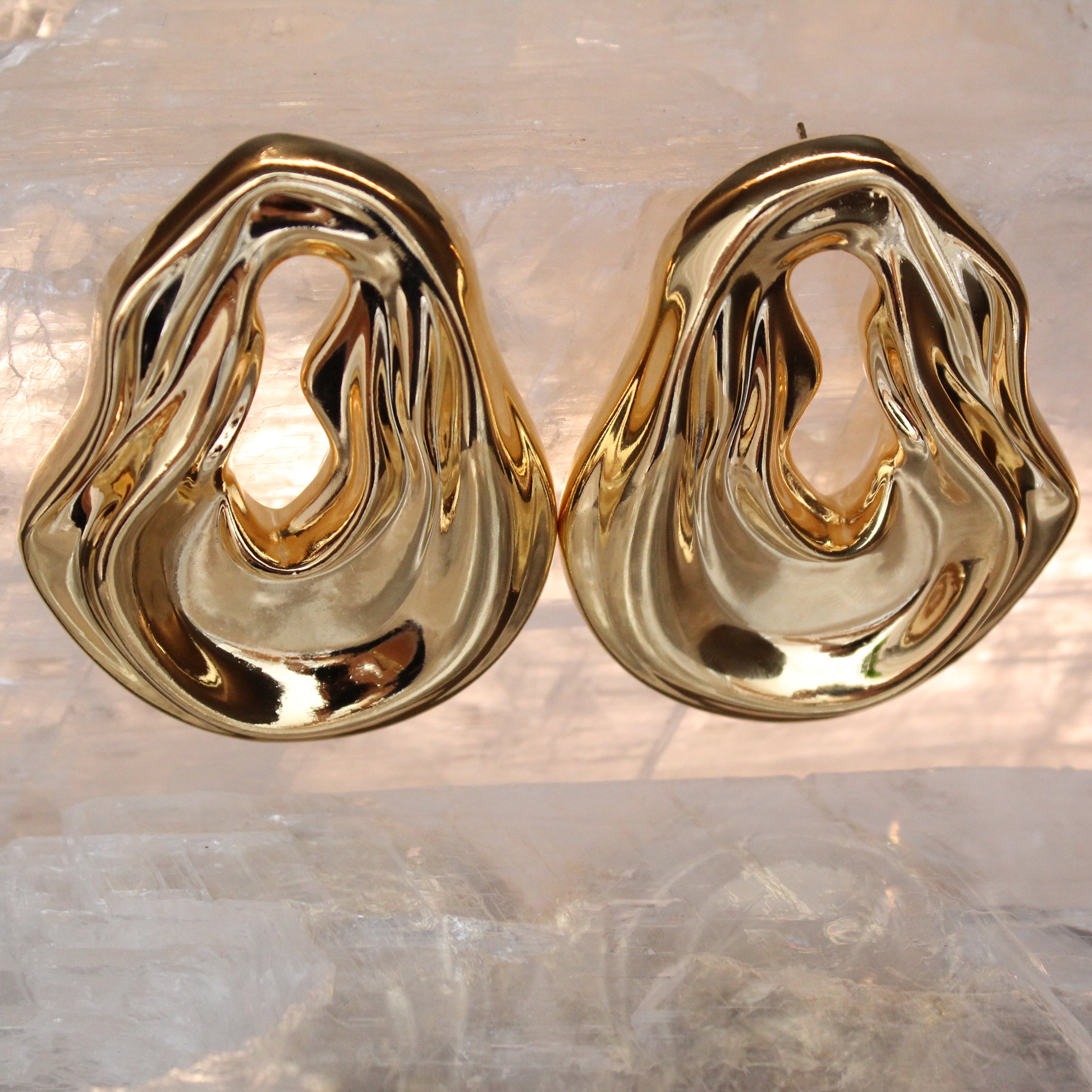 Gold plated abstract oval earrings with large sculptural asymmetric design and polished finish, 61mm by 51mm