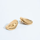 Gold oval sculptural earrings with smooth curved design and polished finish
