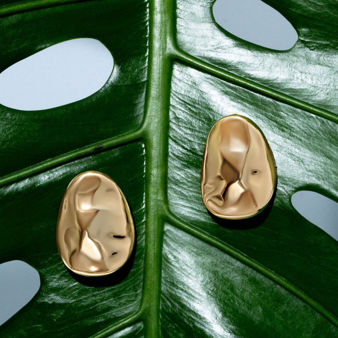 Gold oval sculptural earrings with smooth curved design and polished finish