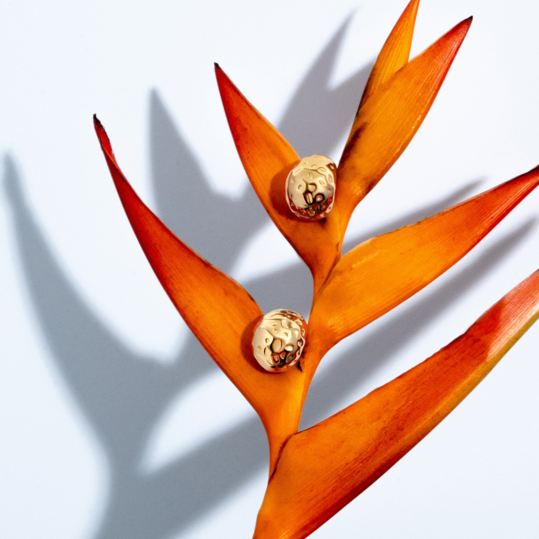 Gold sculptural earrings with compact organic texture and polished finish