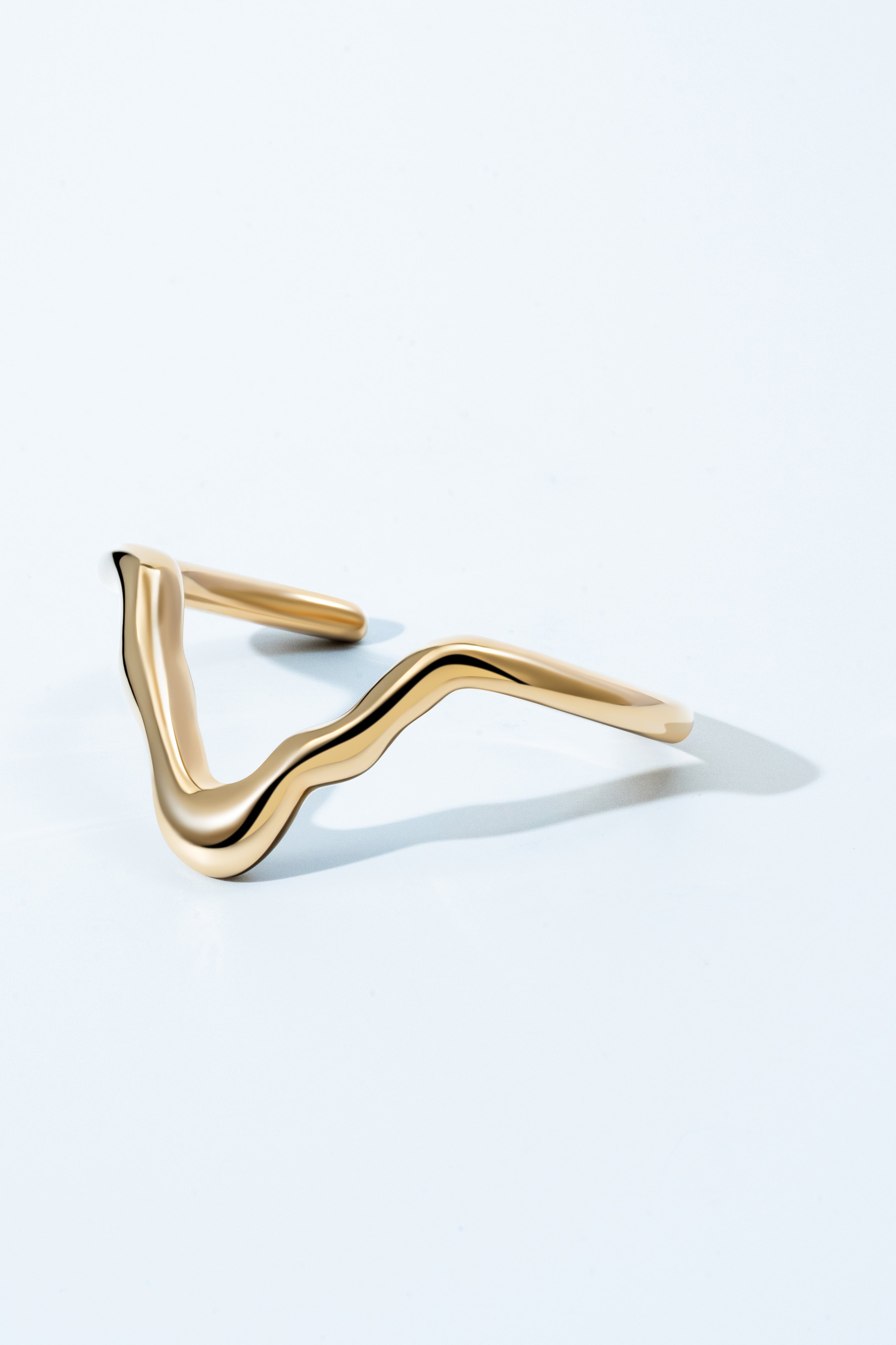 Gold sculptural bracelet with organic curved design and polished finish