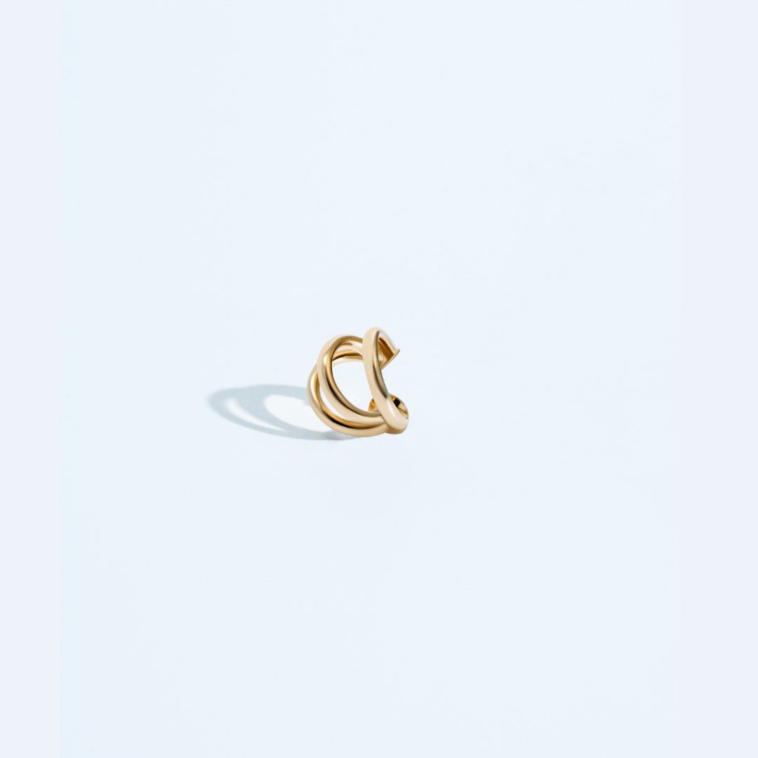 Triple strand ear cuff available in gold plated and rhodium plated finishes with sculptural layered design