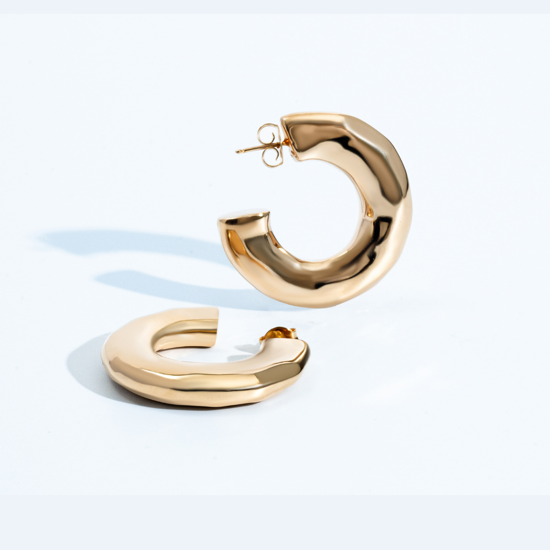 Hammered open hoop earrings available in gold plated and rhodium plated finishes with sculptural texture
