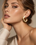 Chunky organic gold hoop earrings with sculptural curved shape and polished finish