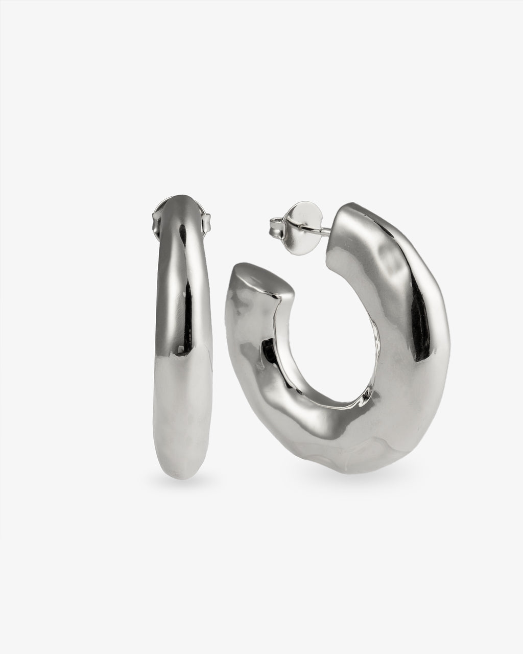 Chunky organic silver hoop earrings with sculptural curved shape and polished finish