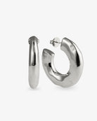 Chunky organic silver hoop earrings with sculptural curved shape and polished finish
