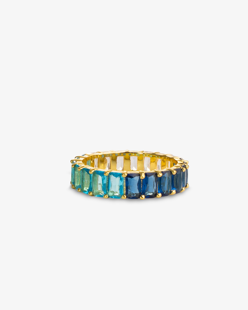 Gold eternity ring with dark-to-light blue ombre simulated diamond stones, alone product shot on a plain background.