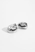 Dome earrings available in gold plated and rhodium plated finishes with dented sculptural texture