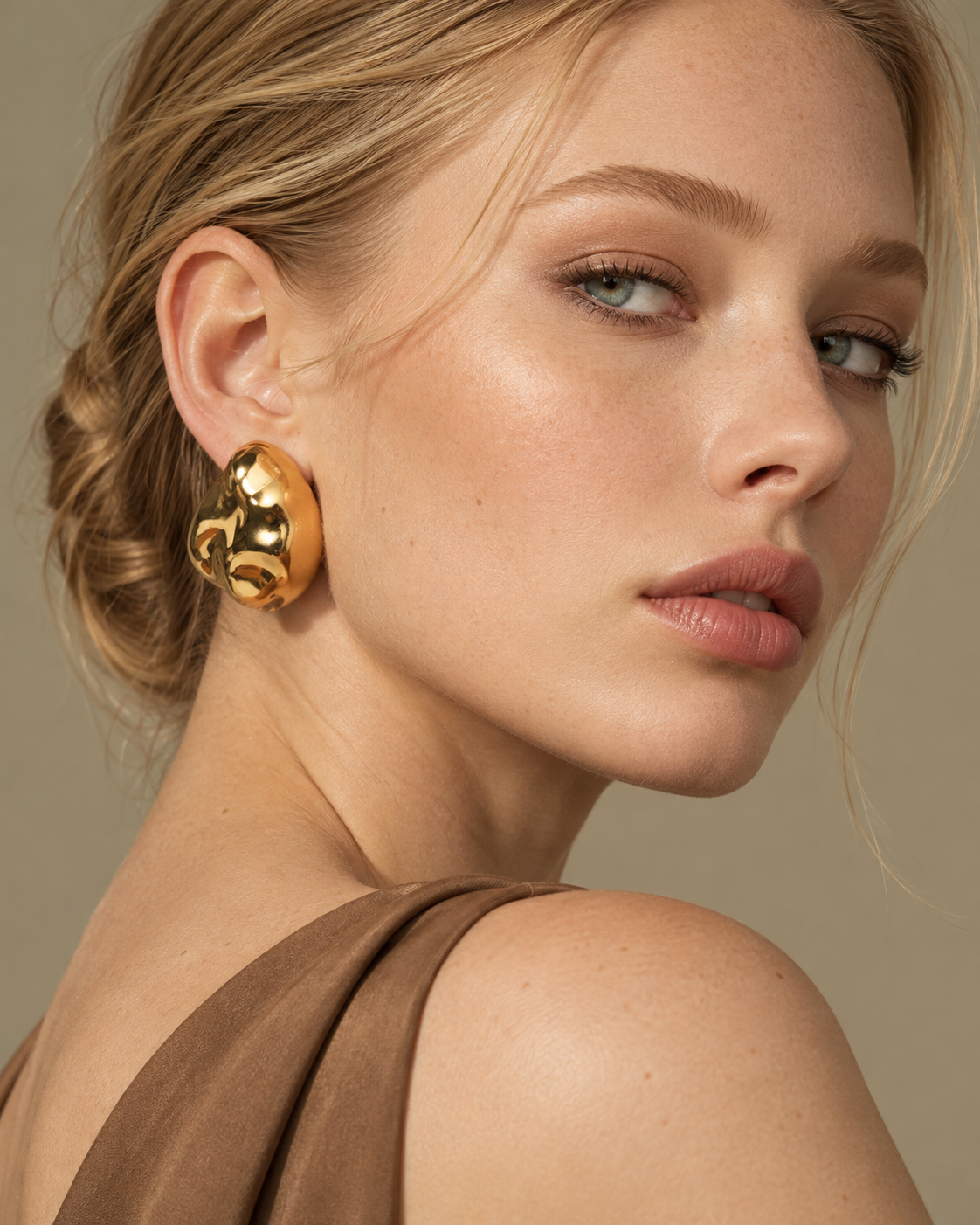 a model earing a Organic pebble gold statement earrings
