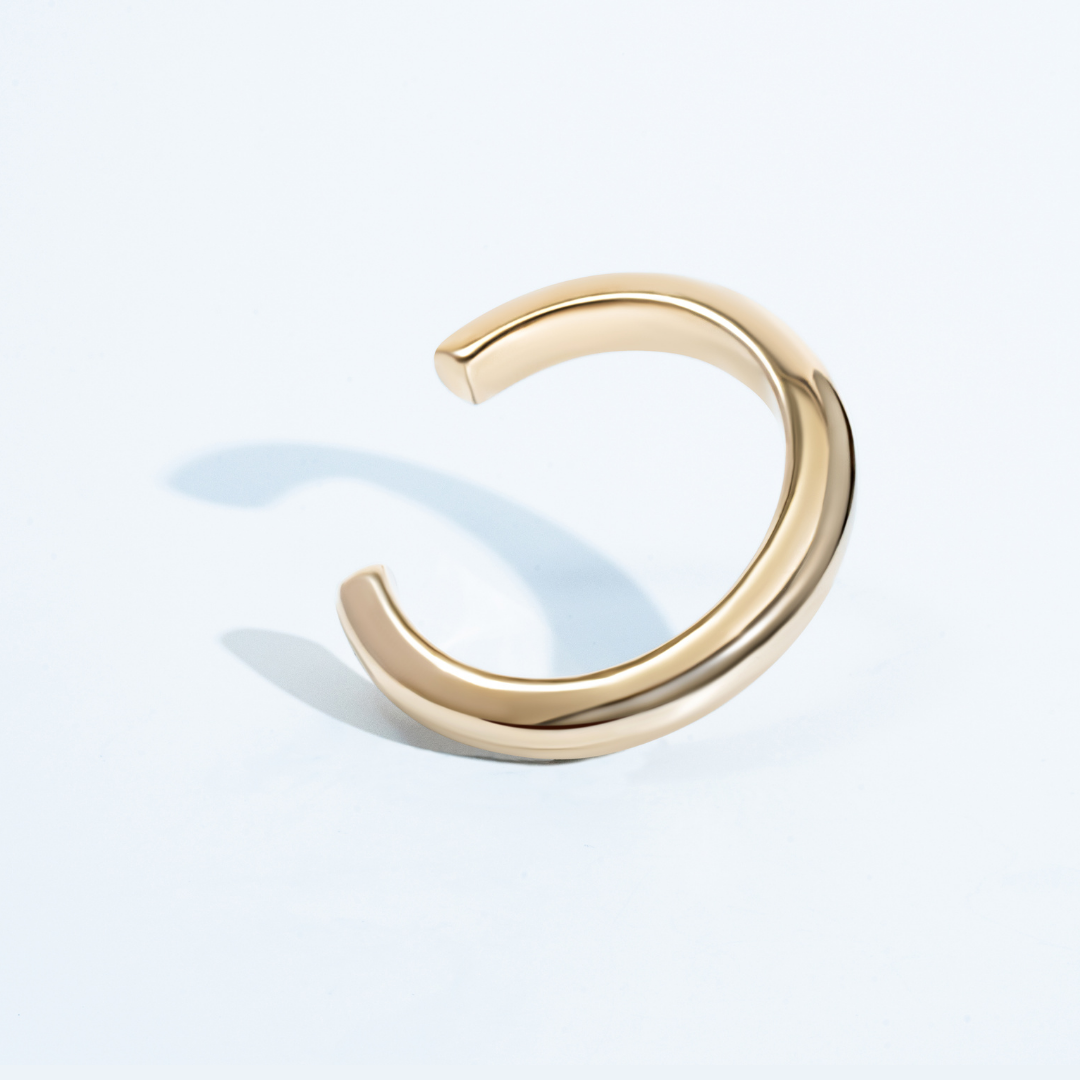 Sculptural cuff bracelet available in gold plated and rhodium plated finishes with bold circular design