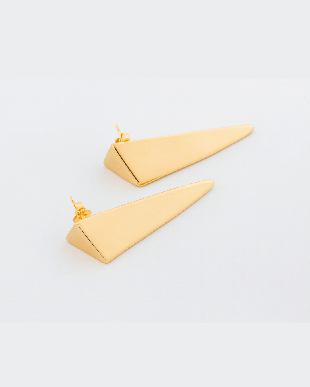 Gold plated elongated drop earrings with tapered sculptural design and polished finish, 60mm length