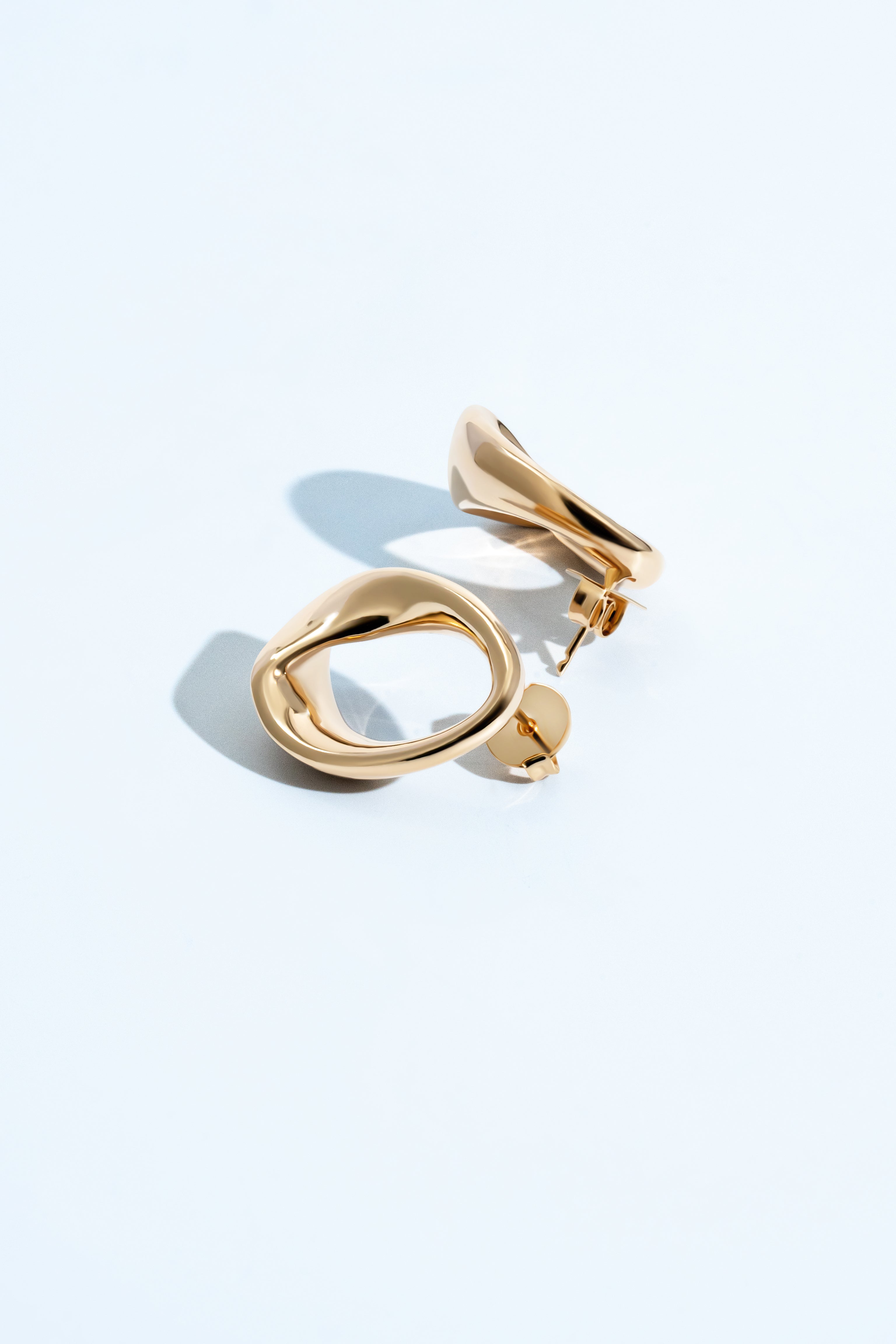 Abstract oval earrings available in gold plated and rhodium plated finishes with sculptural geometric design