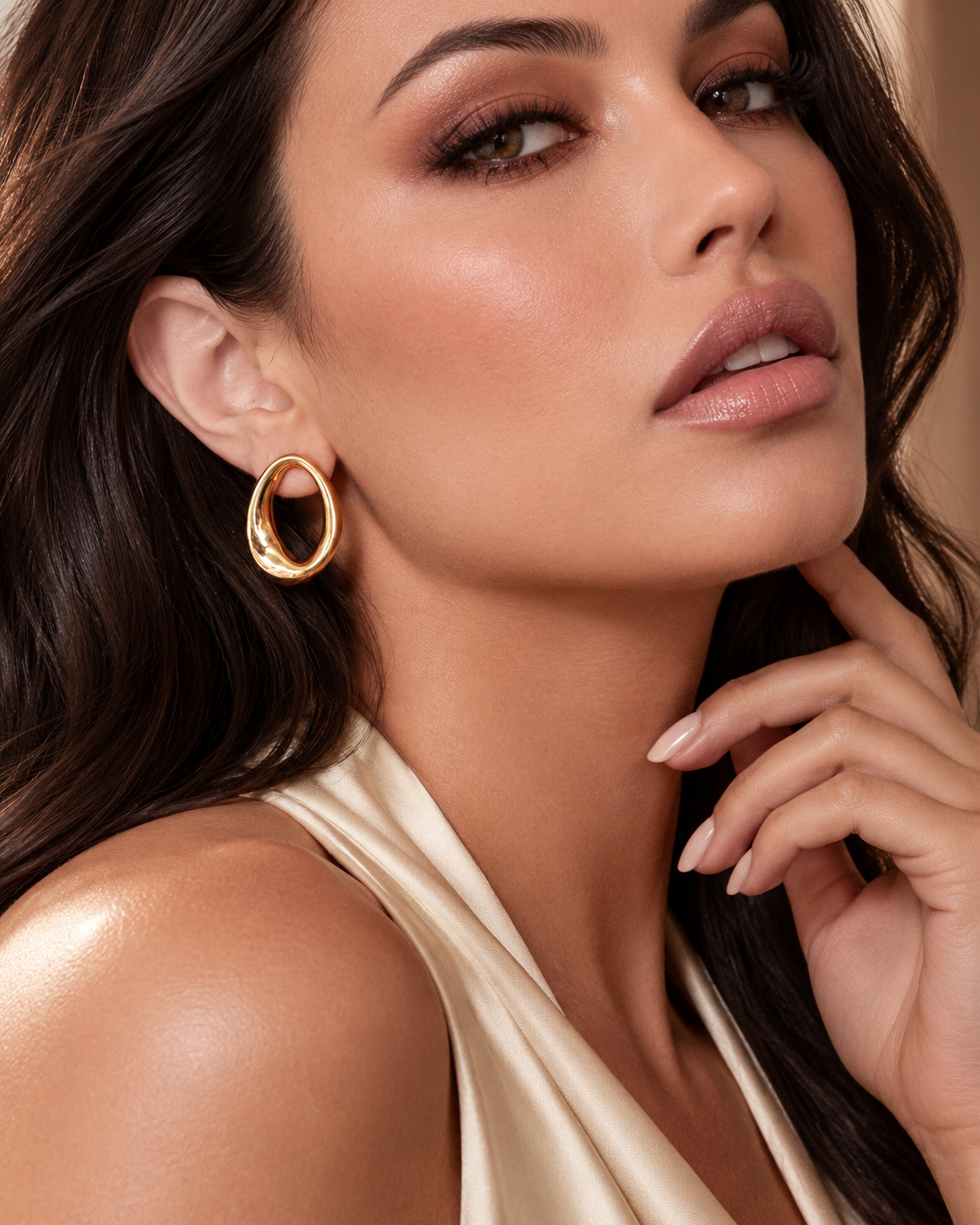 a model earing a gold statement earrings