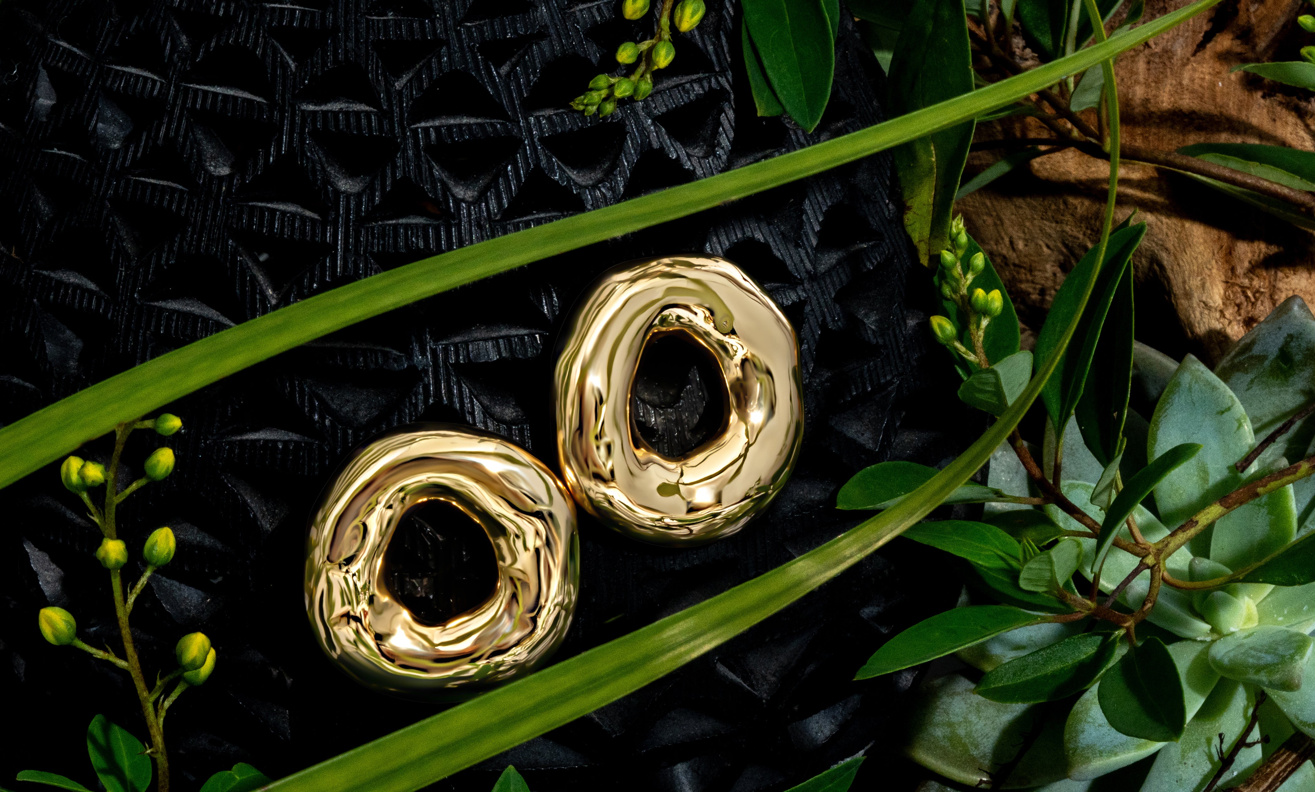 Melted circle earrings available in gold plated and rhodium plated finishes with sculptural curved design