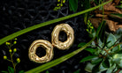 Melted circle earrings available in gold plated and rhodium plated finishes with sculptural curved design