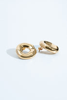 Melted circle earrings available in gold plated and rhodium plated finishes with sculptural curved design