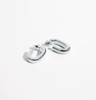 Oval open hoop earrings available in gold plated and rhodium plated finishes with sculptural curved design