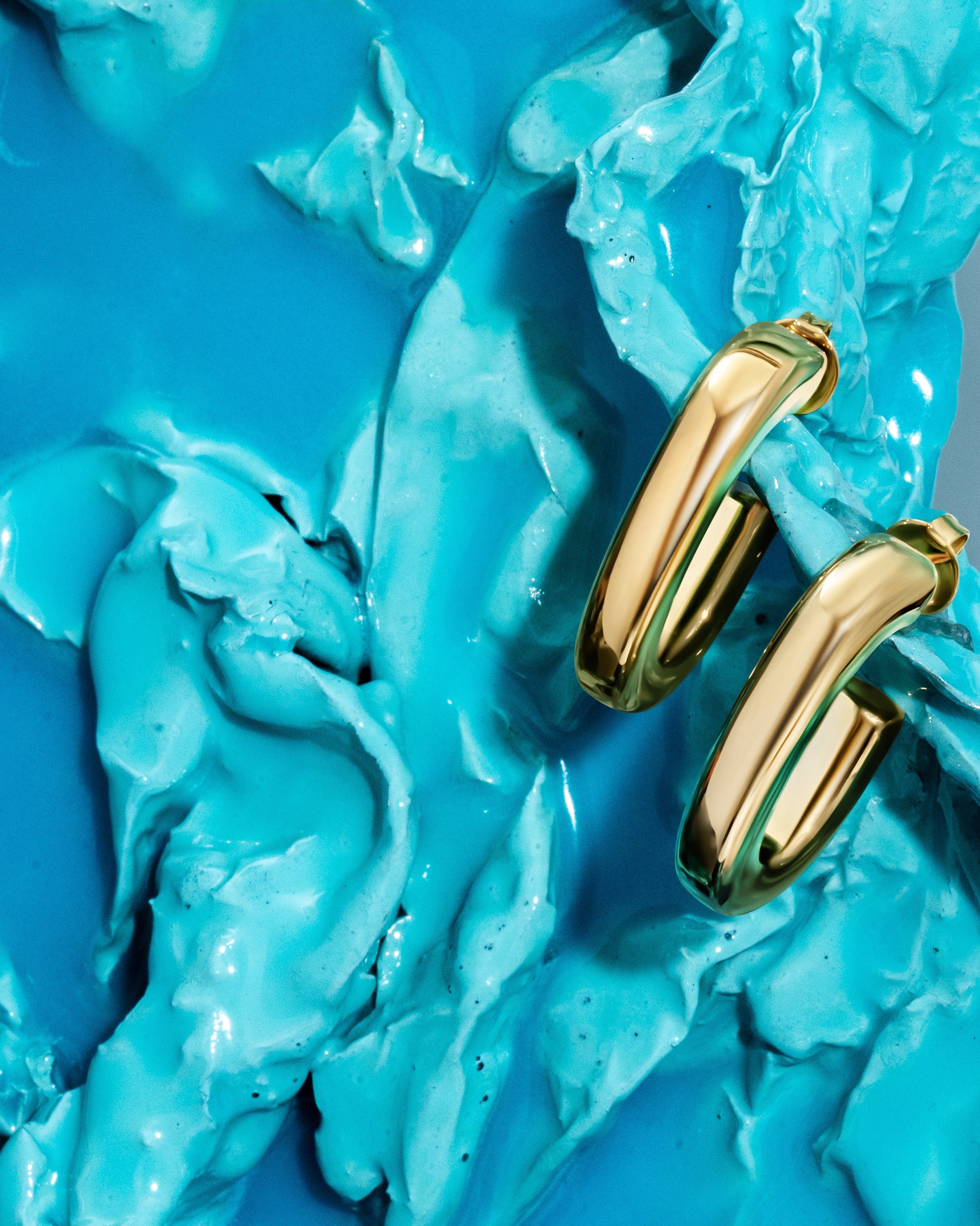 Oval open hoop earrings available in gold plated and rhodium plated finishes with sculptural curved design