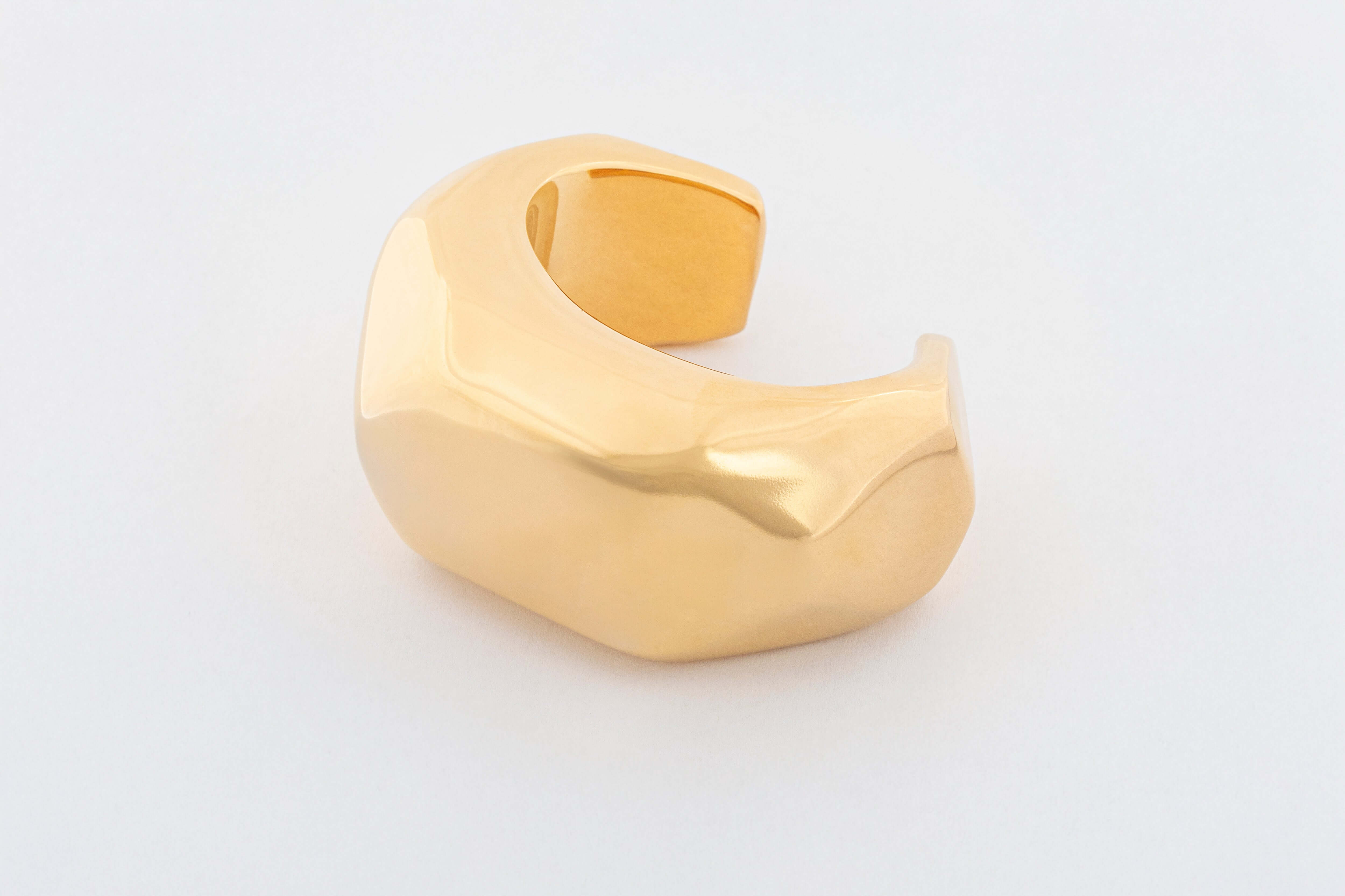 Gold plated asymmetric wide bracelet with sculptural curved design and polished finish, 42mm