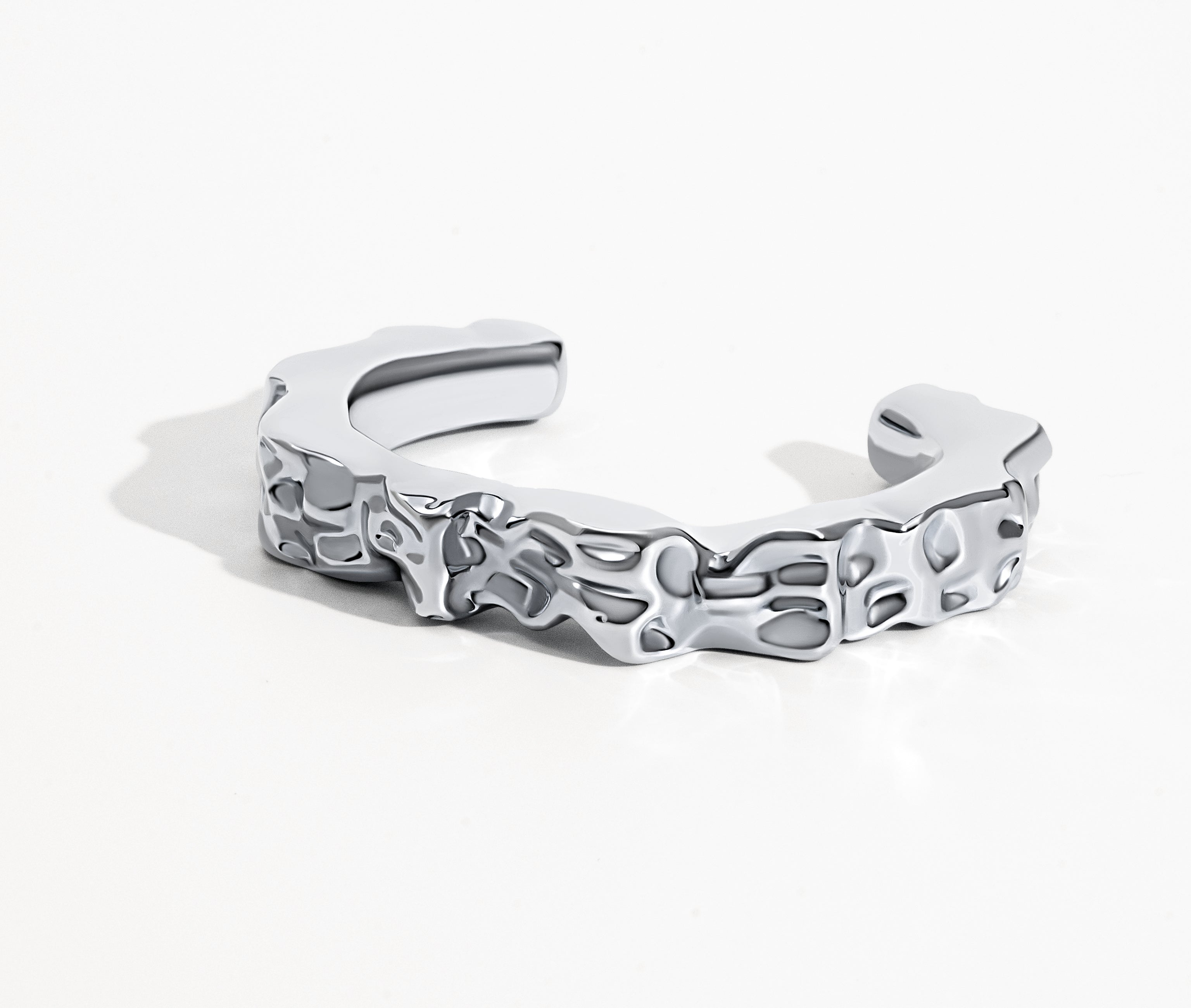 Sculpted hammered cuff bracelet available in gold plated and rhodium plated finishes with organic texture