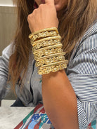 Sculptural gold cuff bracelet with irregular hammered texture on the arm