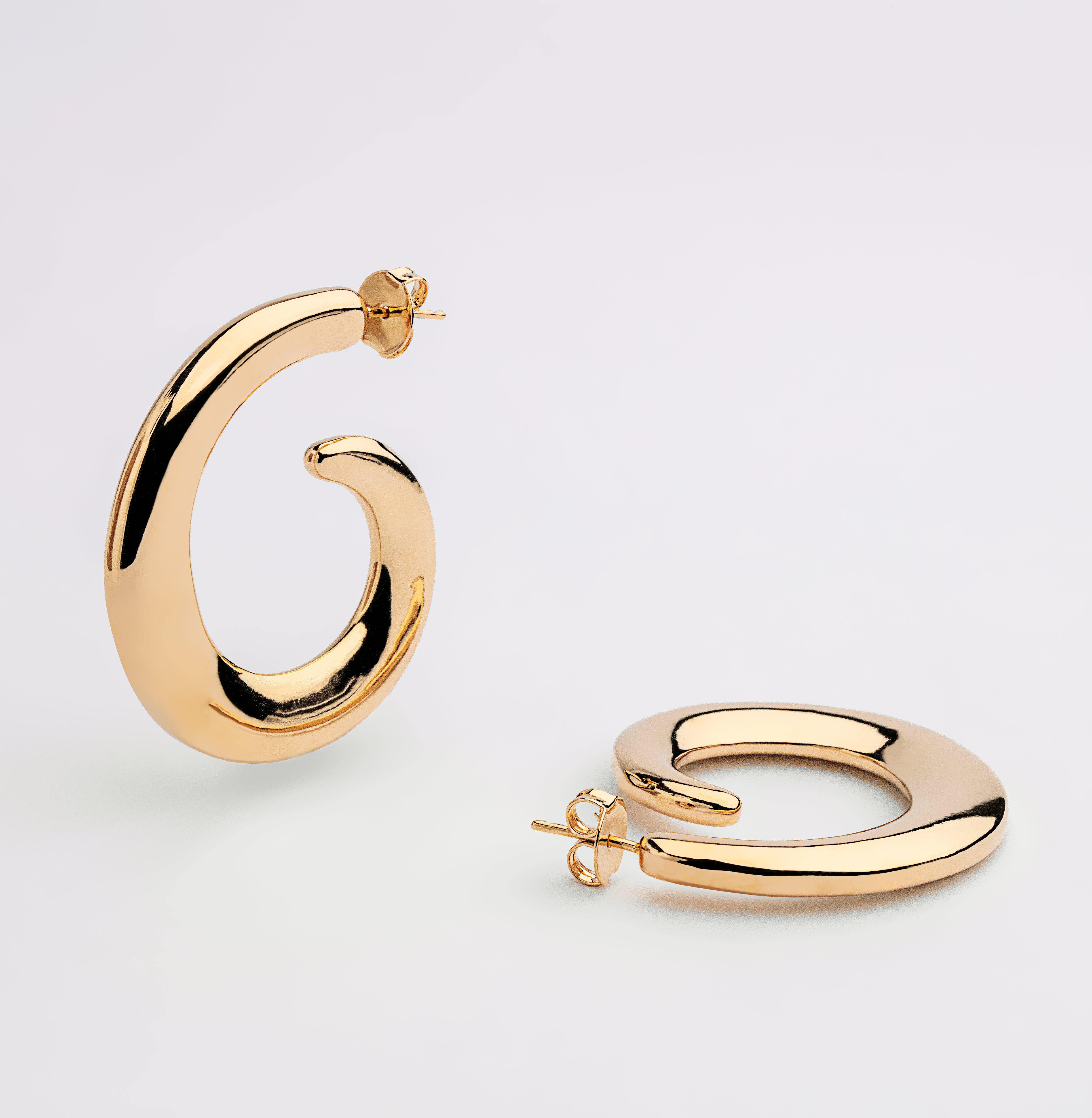 Gold plated loop dangle earrings with fluid curved design and polished finish