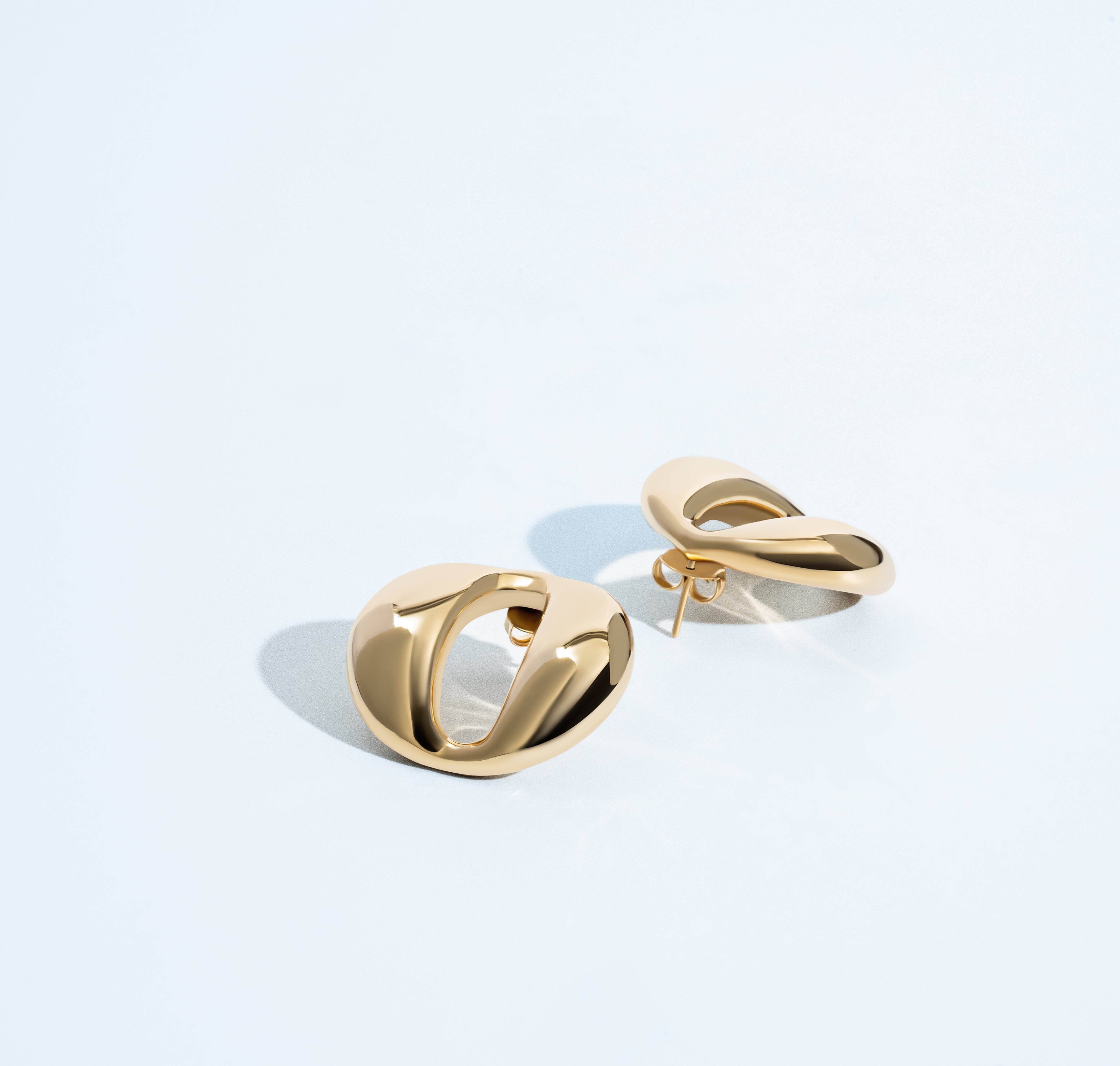 Dome earrings available in gold plated and rhodium plated finishes with smooth sculptural design