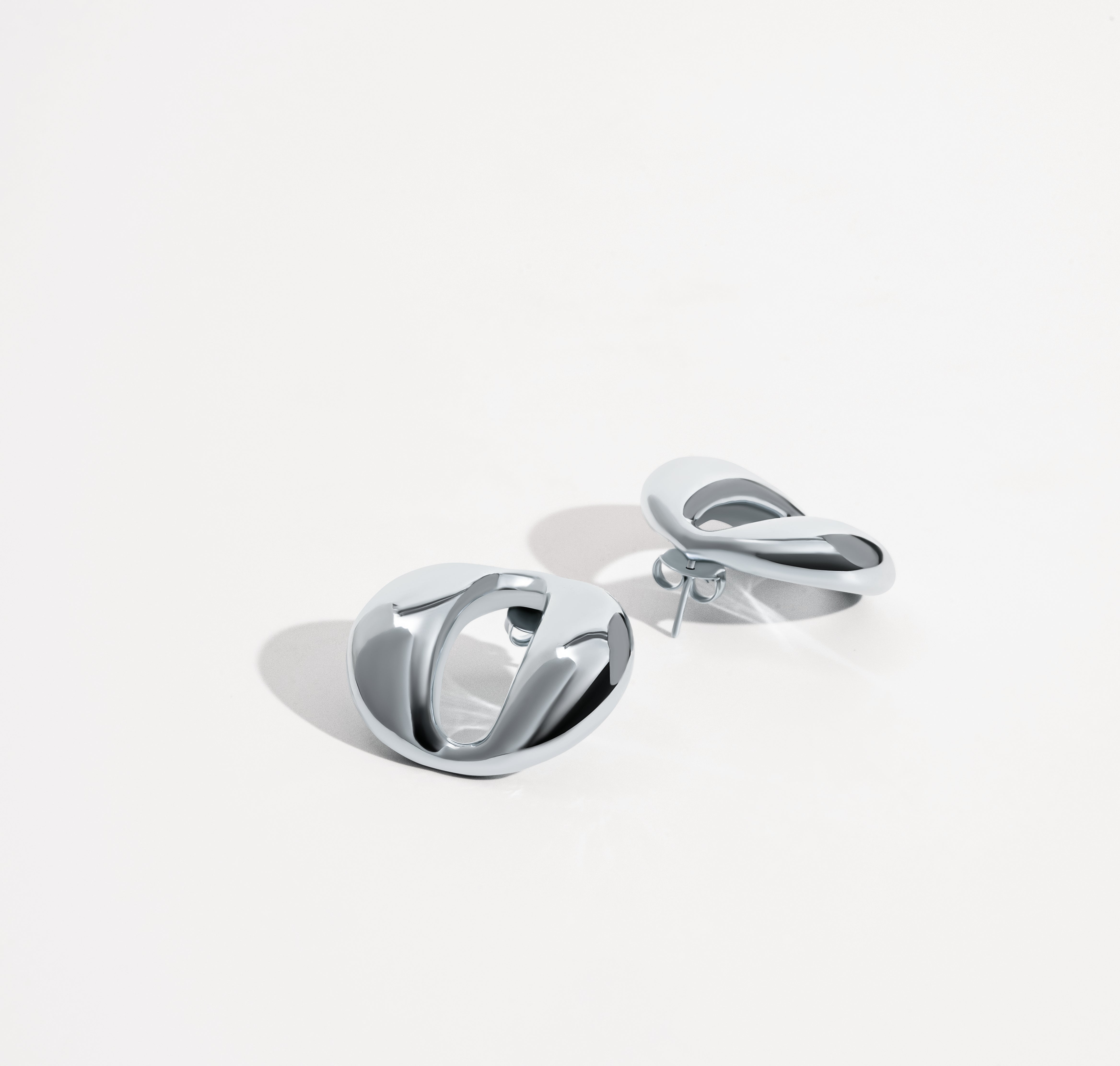 Dome earrings available in gold plated and rhodium plated finishes with smooth sculptural design