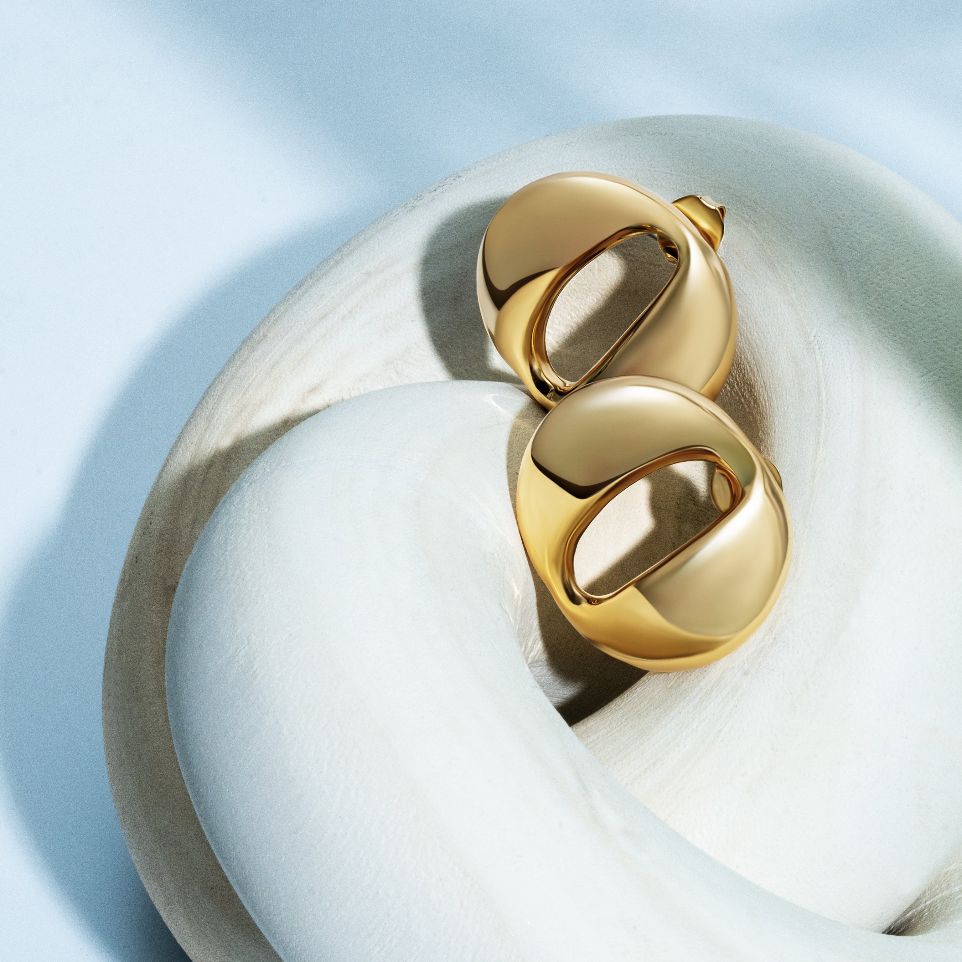 Dome earrings available in gold plated and rhodium plated finishes with smooth sculptural design