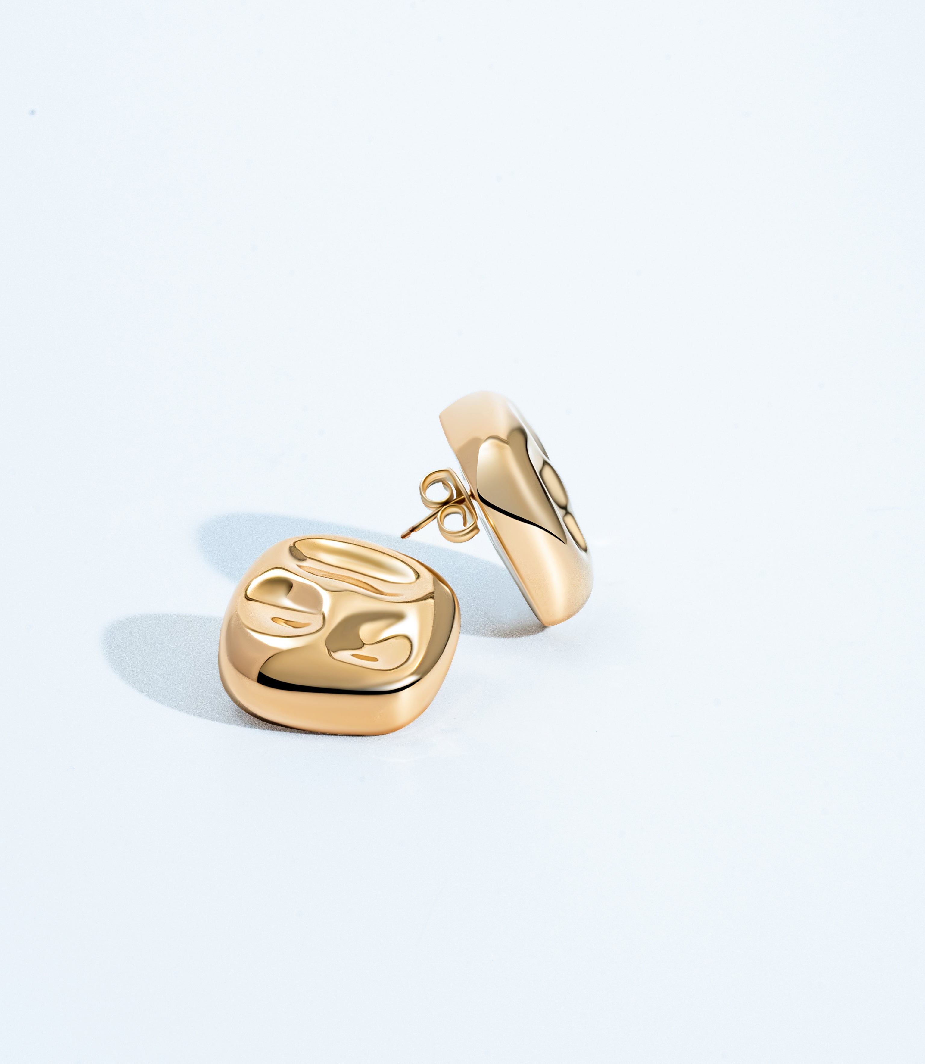 Square hammered earrings available in gold plated and rhodium plated finishes with geometric sculptural design