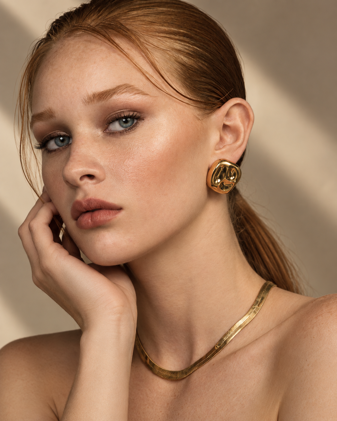 a model wearing a Organic square gold statement earrings