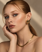 a model wearing a Organic square gold statement earrings