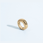 Gold sculptural ring with organic circular shape and polished finish