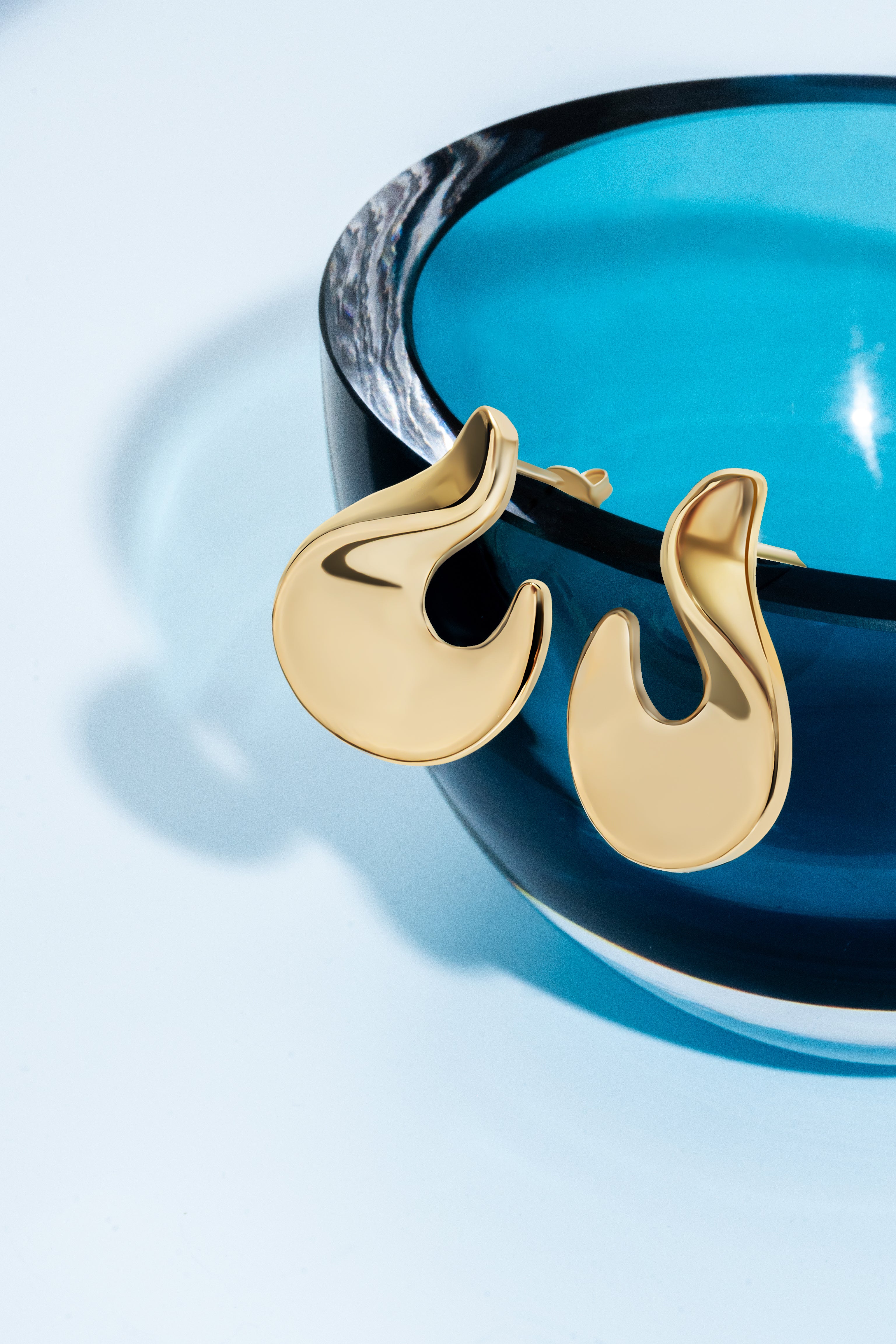 Abstract hook earrings available in gold plated and rhodium plated finishes with sculptural curved design