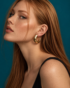 a model wearing a Chunky sculptural gold hoop earrings 