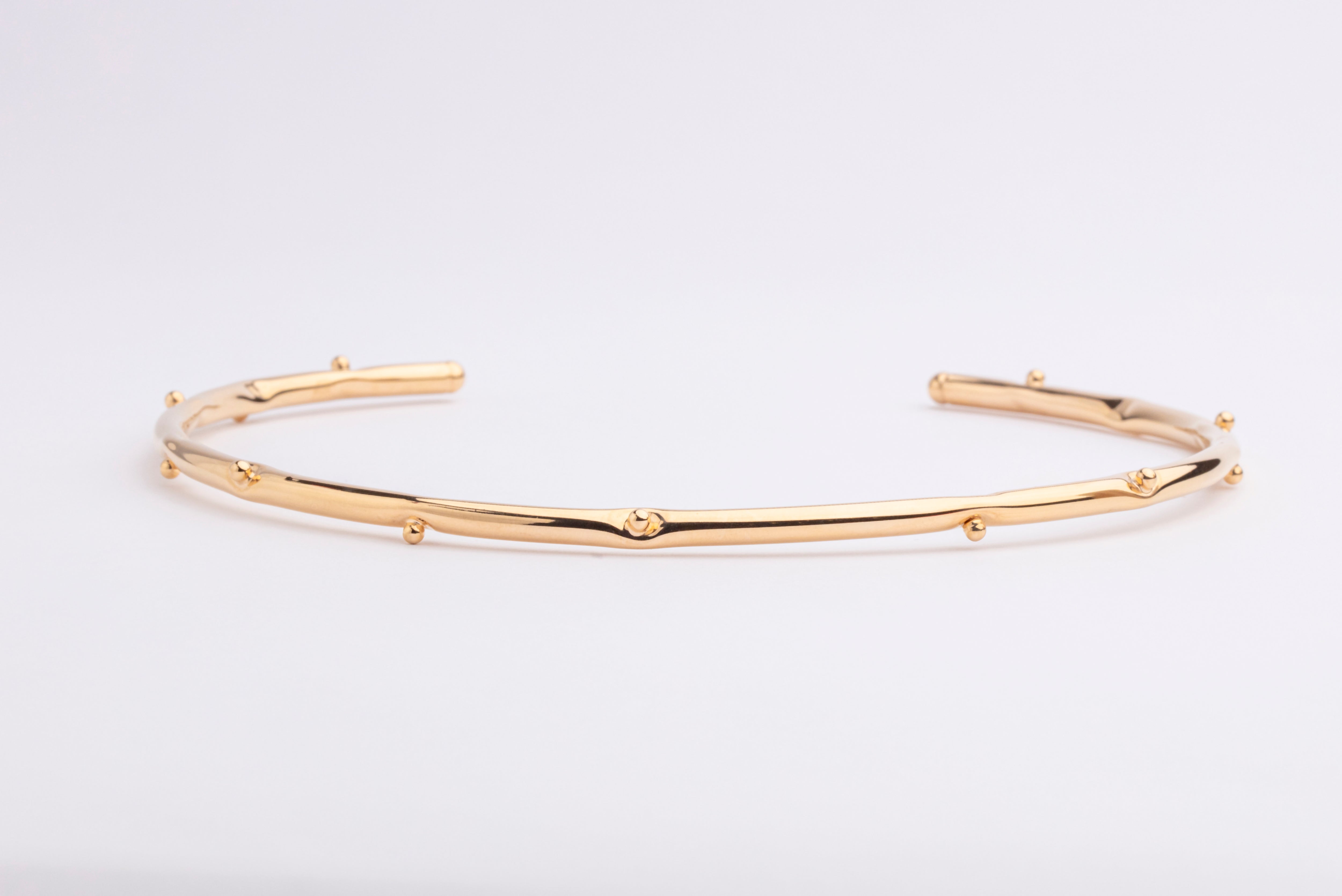 Bold gold plated bracelet with clean structured design and polished finish